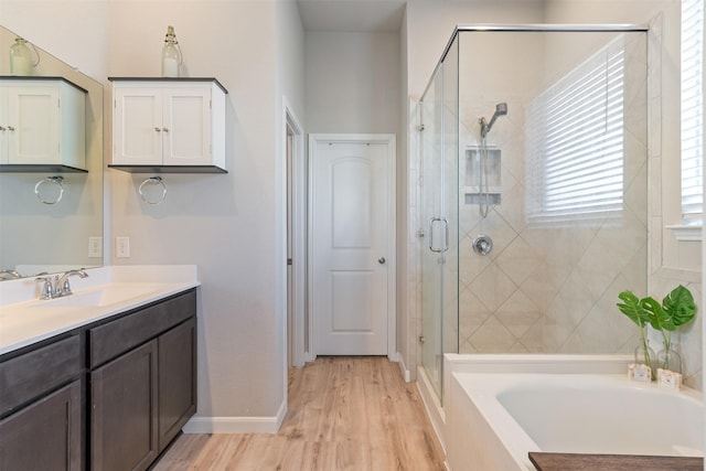 bathroom with separate shower and tub, vanity, and hardwood / wood-style flooring