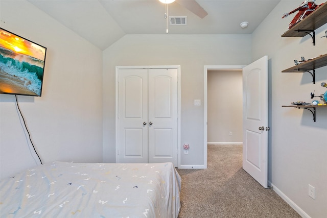 unfurnished bedroom featuring lofted ceiling, a closet, ceiling fan, and light colored carpet