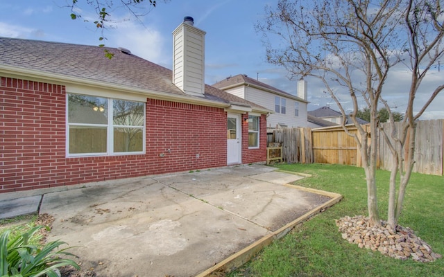 rear view of property featuring a patio and a lawn