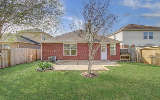 rear view of property featuring a lawn, central AC, and a patio