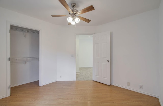 unfurnished bedroom with ceiling fan, a closet, and light wood-type flooring