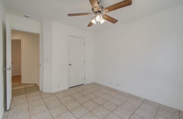 spare room with ceiling fan and light tile patterned flooring