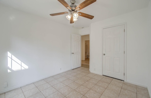 empty room featuring ceiling fan and light tile patterned floors