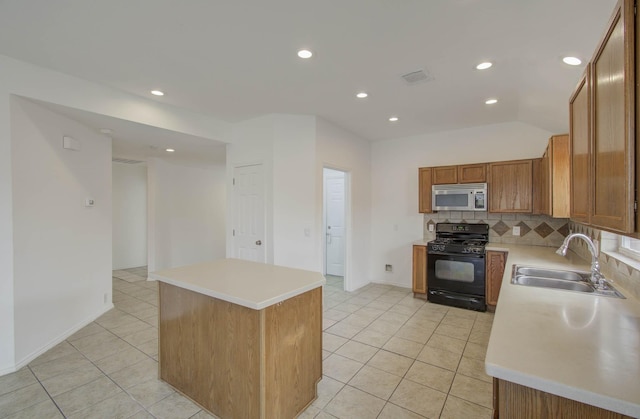 kitchen featuring sink, light tile patterned floors, tasteful backsplash, a kitchen island, and black range with gas cooktop