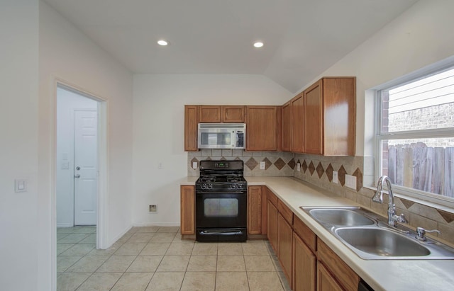 kitchen featuring sink, vaulted ceiling, black gas range oven, tasteful backsplash, and light tile patterned flooring