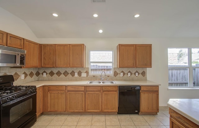 kitchen with sink, backsplash, vaulted ceiling, and black appliances