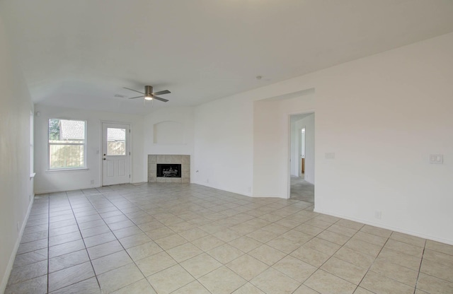 unfurnished living room featuring a fireplace, ceiling fan, and light tile patterned flooring