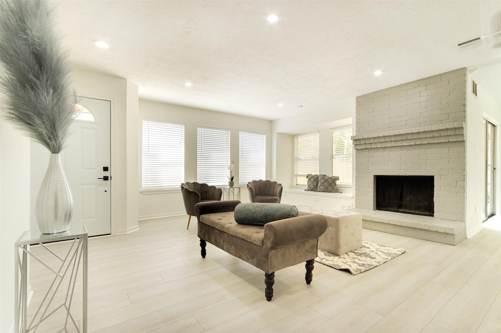 living room with a fireplace and light wood-type flooring