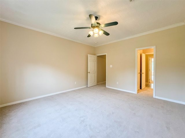 unfurnished bedroom with ceiling fan, light colored carpet, ensuite bathroom, and ornamental molding