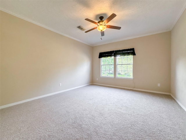 carpeted spare room featuring ceiling fan, ornamental molding, and a textured ceiling