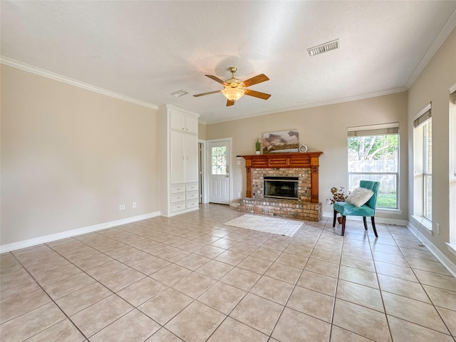 unfurnished living room featuring ceiling fan, a brick fireplace, a textured ceiling, light tile patterned flooring, and ornamental molding