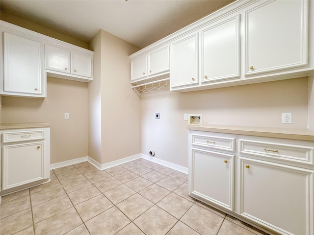 washroom with electric dryer hookup, light tile patterned floors, cabinets, and washer hookup