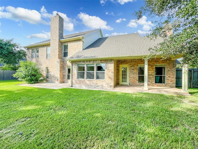 back of property featuring a yard and a patio