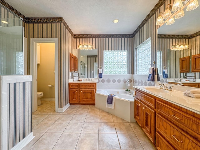 bathroom with vanity, tile patterned floors, a washtub, toilet, and a textured ceiling