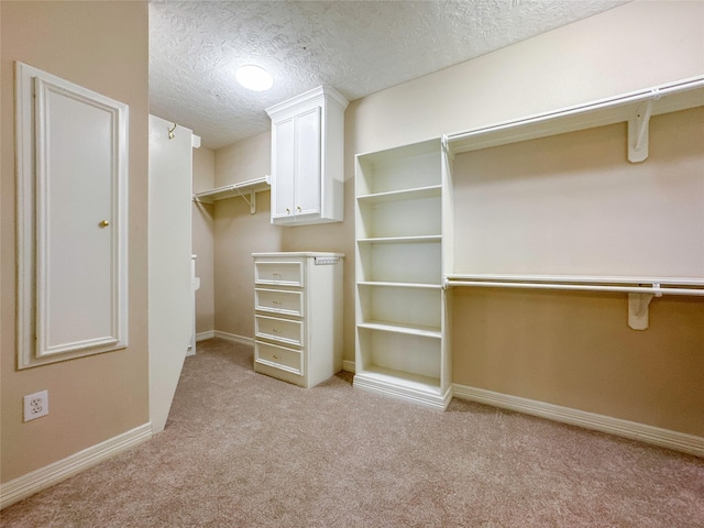 walk in closet featuring light colored carpet