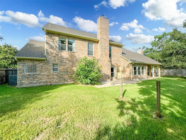 back of house with a patio area and a yard