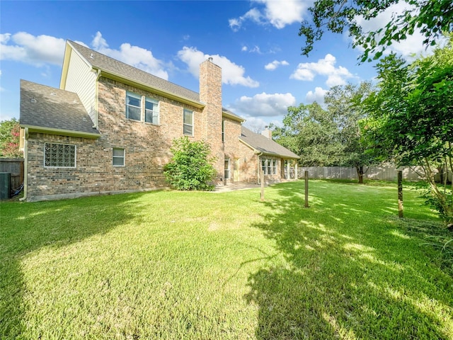 back of property with cooling unit and a yard