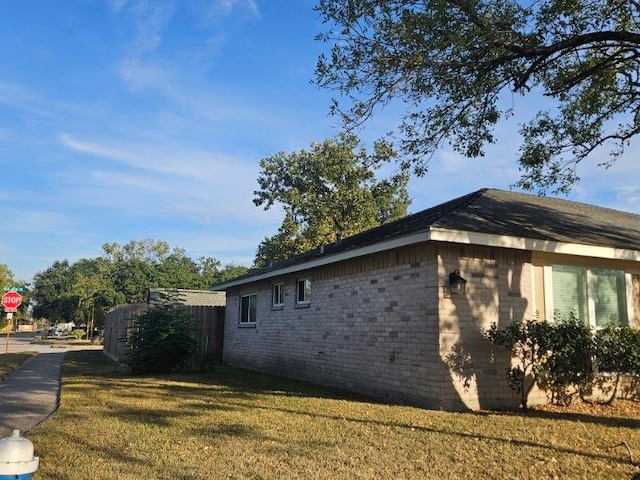 view of side of home with a yard