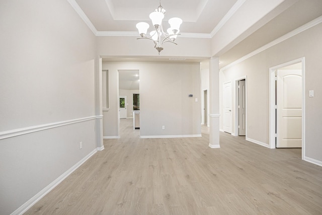 unfurnished dining area with a notable chandelier, light hardwood / wood-style flooring, and a tray ceiling