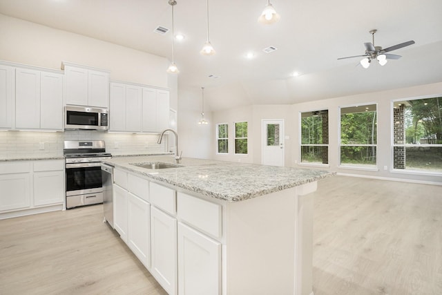 kitchen with a center island with sink, sink, white cabinetry, and stainless steel appliances