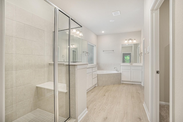 bathroom featuring hardwood / wood-style floors, vanity, and separate shower and tub