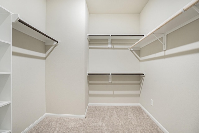 walk in closet featuring light colored carpet