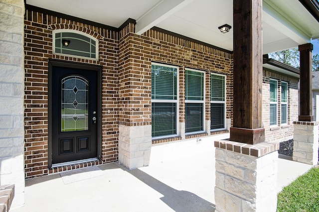 view of exterior entry featuring covered porch