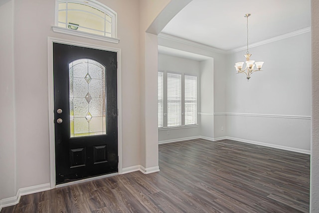 foyer entrance with a notable chandelier, dark hardwood / wood-style floors, and ornamental molding