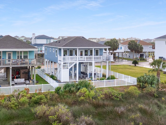 rear view of house with an outdoor living space, a balcony, a patio, and a lawn