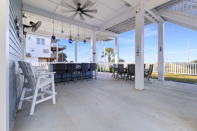 view of patio featuring ceiling fan and a bar