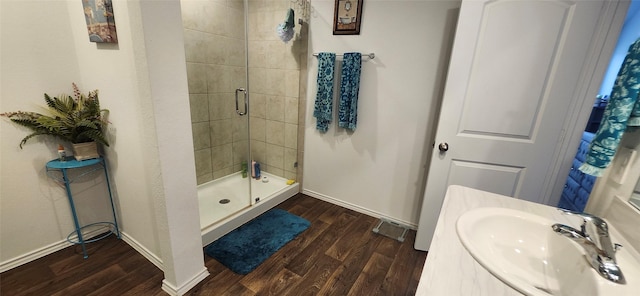 bathroom featuring sink, a shower with door, and hardwood / wood-style flooring