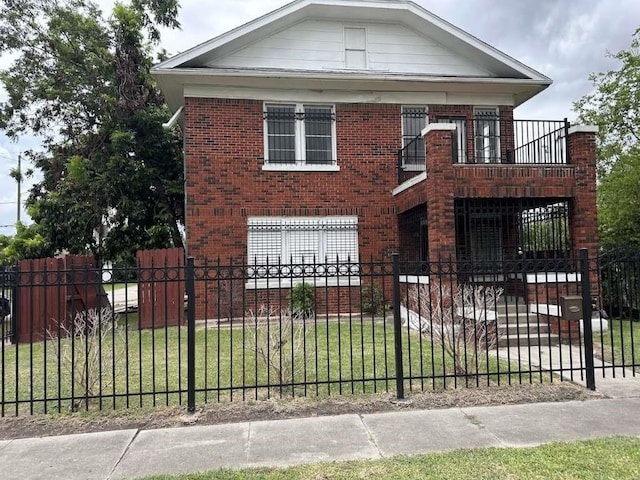 view of front facade featuring a balcony and a front lawn