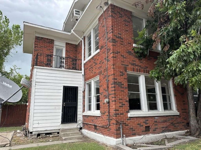 rear view of property featuring a balcony and a wall mounted AC