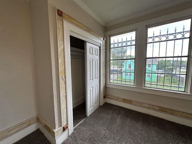 unfurnished bedroom featuring a closet, dark carpet, and ornamental molding