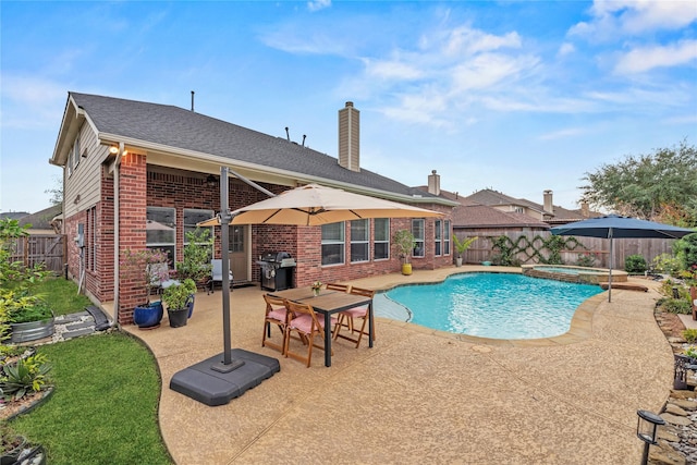 view of swimming pool with an in ground hot tub, a patio, and a grill