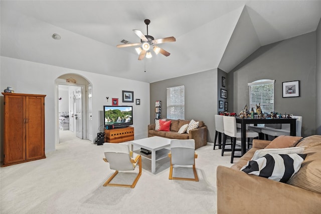 carpeted living room with ceiling fan and lofted ceiling