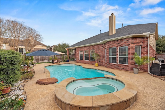 view of pool featuring a patio area and an in ground hot tub