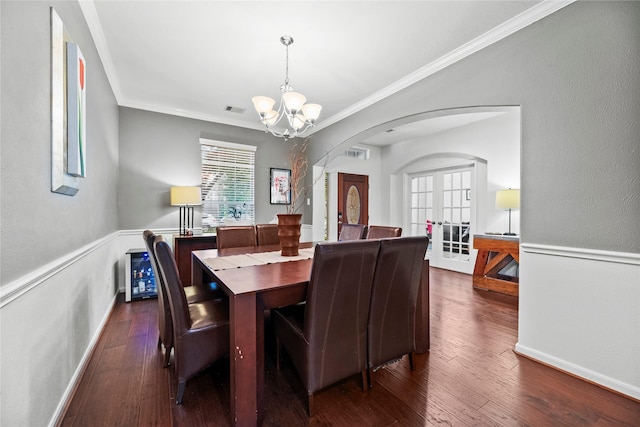 dining space with a chandelier, french doors, dark hardwood / wood-style flooring, and ornamental molding