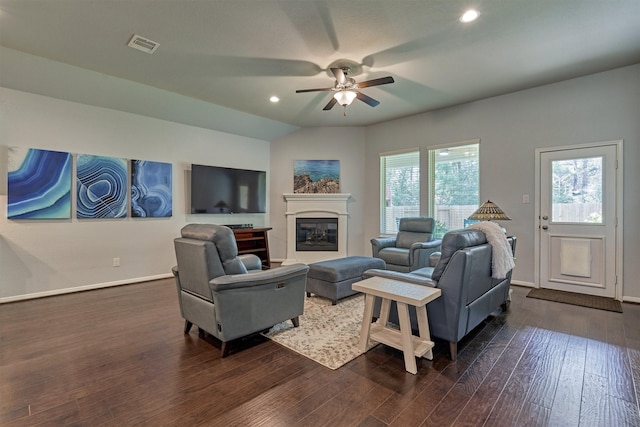 living room with plenty of natural light, ceiling fan, dark hardwood / wood-style flooring, and vaulted ceiling