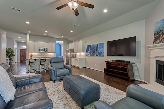 living room featuring ceiling fan and dark hardwood / wood-style flooring