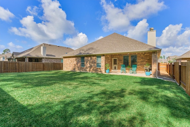 rear view of house with a patio and a lawn