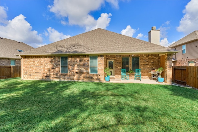 rear view of house featuring a patio area and a yard