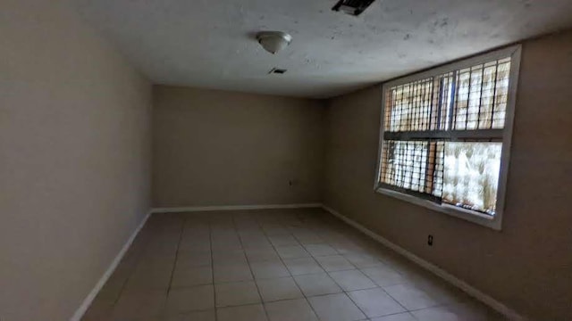 tiled empty room featuring a wealth of natural light