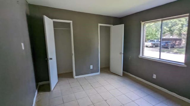 unfurnished bedroom with light tile patterned floors and a closet