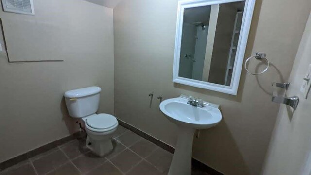 bathroom featuring tile patterned flooring, toilet, and sink