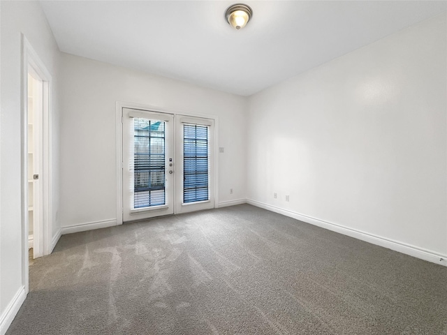 carpeted spare room featuring french doors