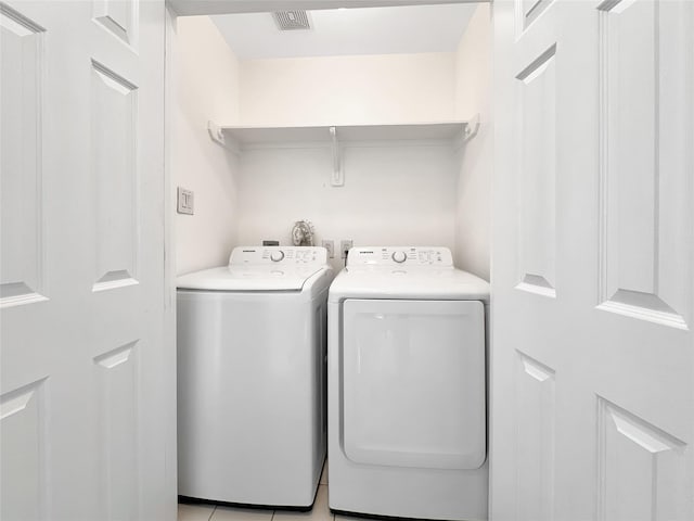 laundry room with washing machine and dryer and light tile patterned flooring