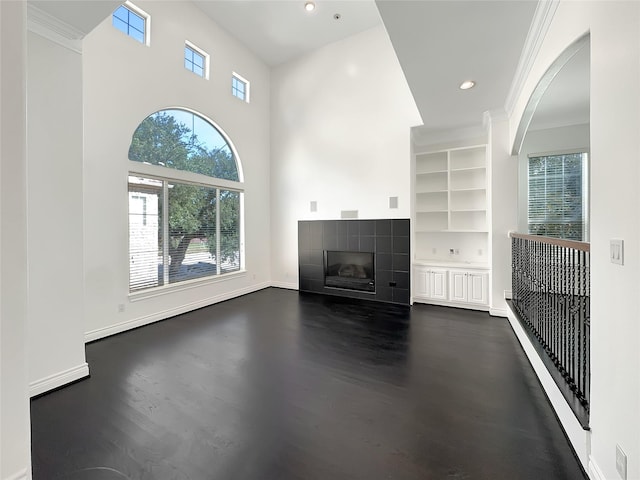 unfurnished living room featuring a healthy amount of sunlight, crown molding, and a fireplace