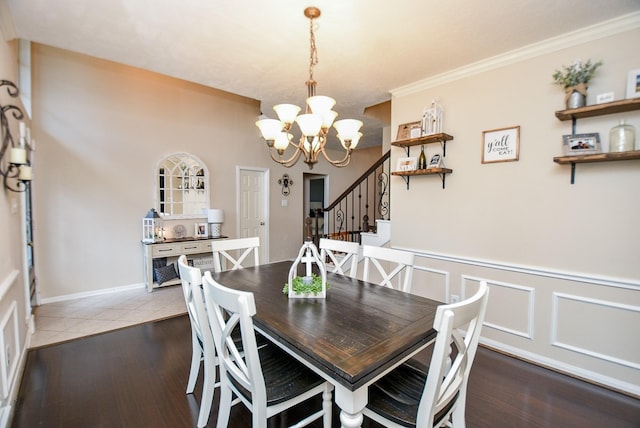 dining space with hardwood / wood-style floors, an inviting chandelier, and crown molding