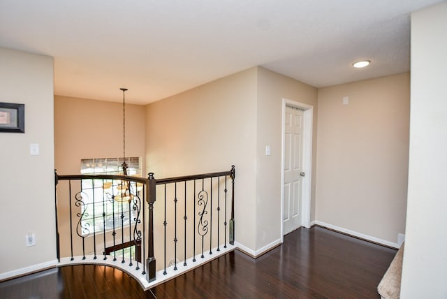 hall with dark hardwood / wood-style floors and a notable chandelier